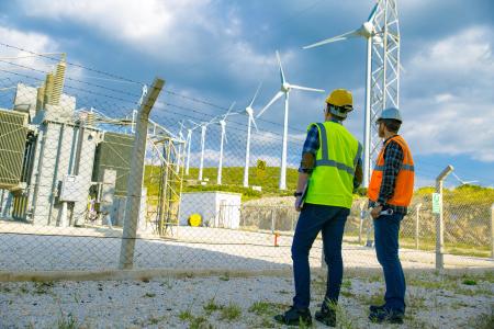 Workers looking at wind power and transfer station