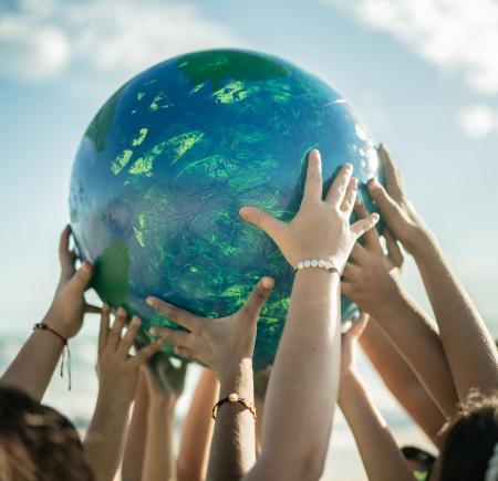 childrens hands holding earth globe